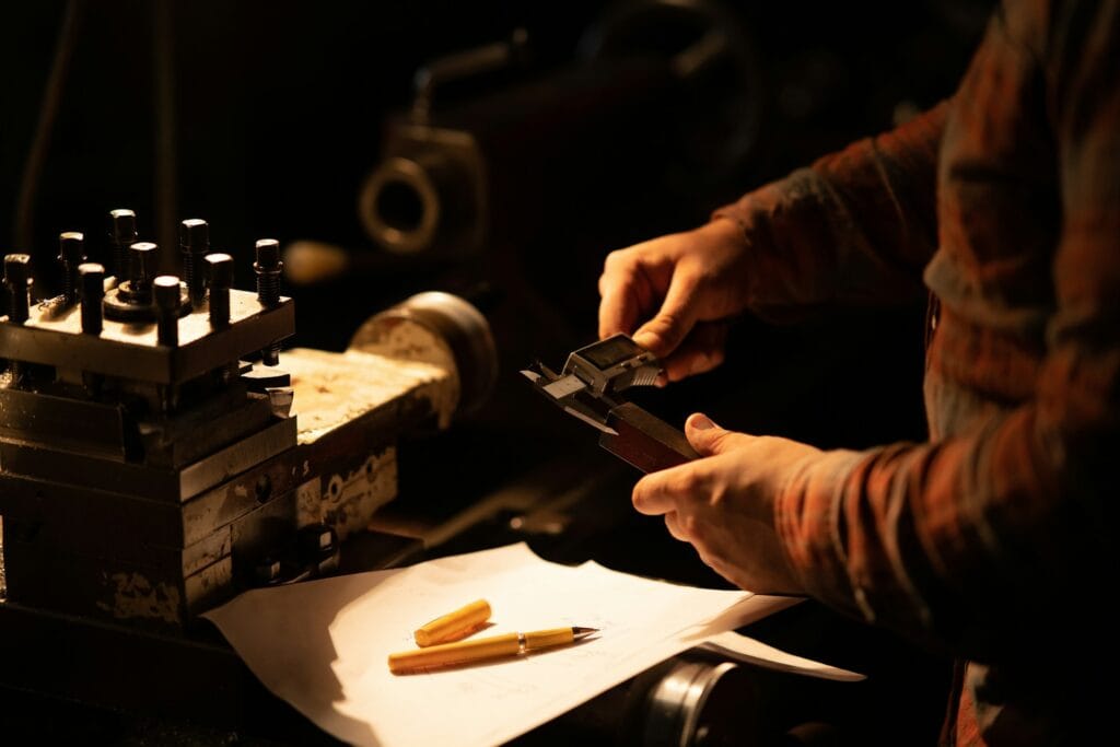 Skilled technician measuring a precision part with a caliper in Deli-Newdexin factory.